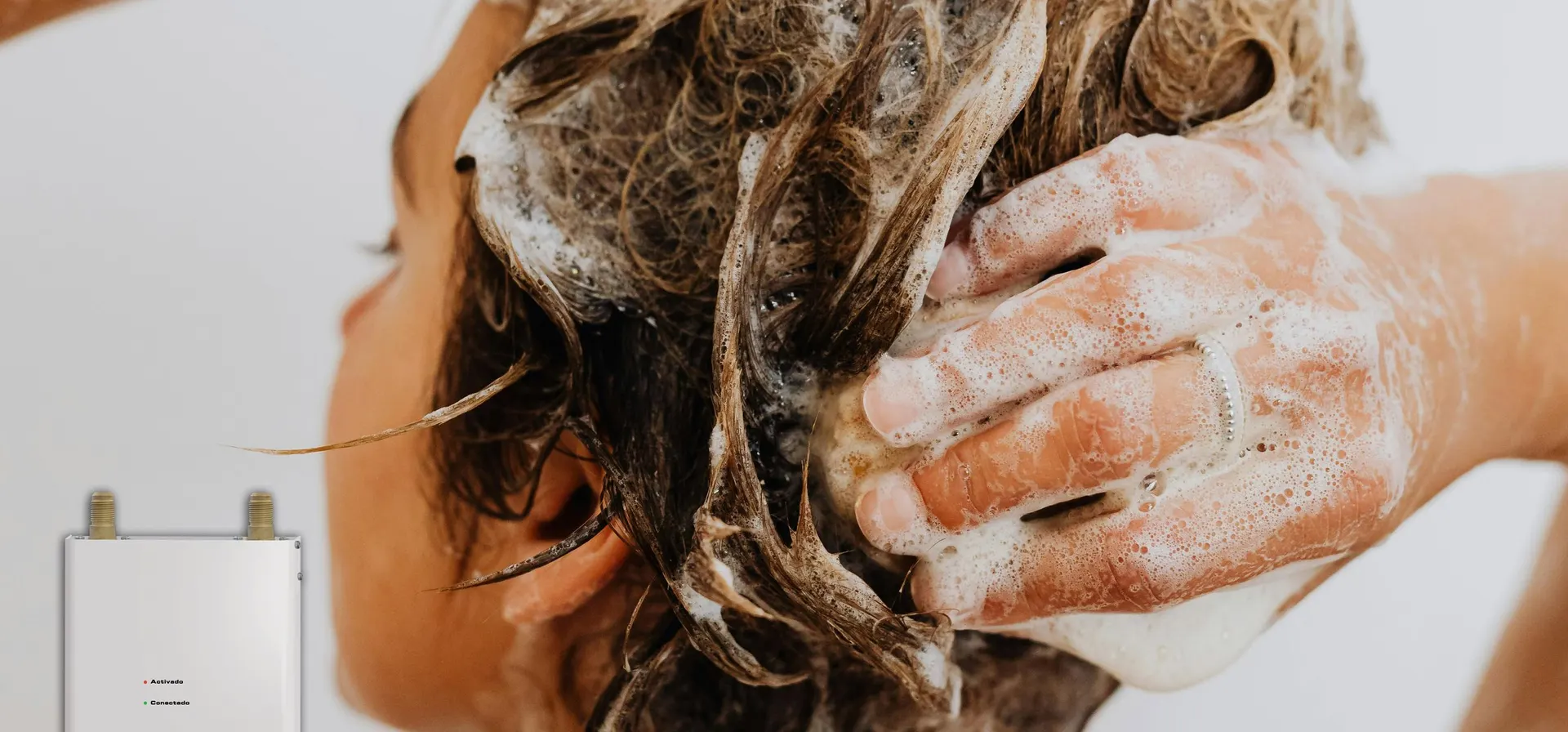 Persona lavándose el cabello bajo agua caliente